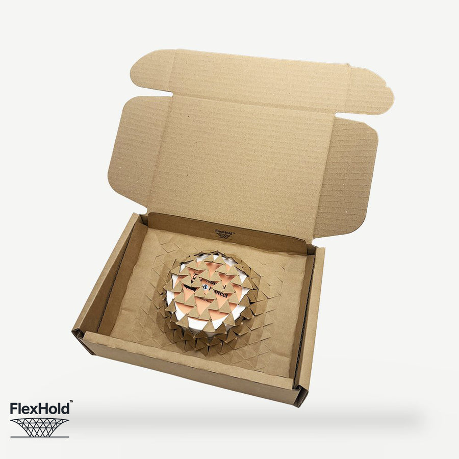 FlexHold box being packed — product placed straight onto the retention panel with no void fill